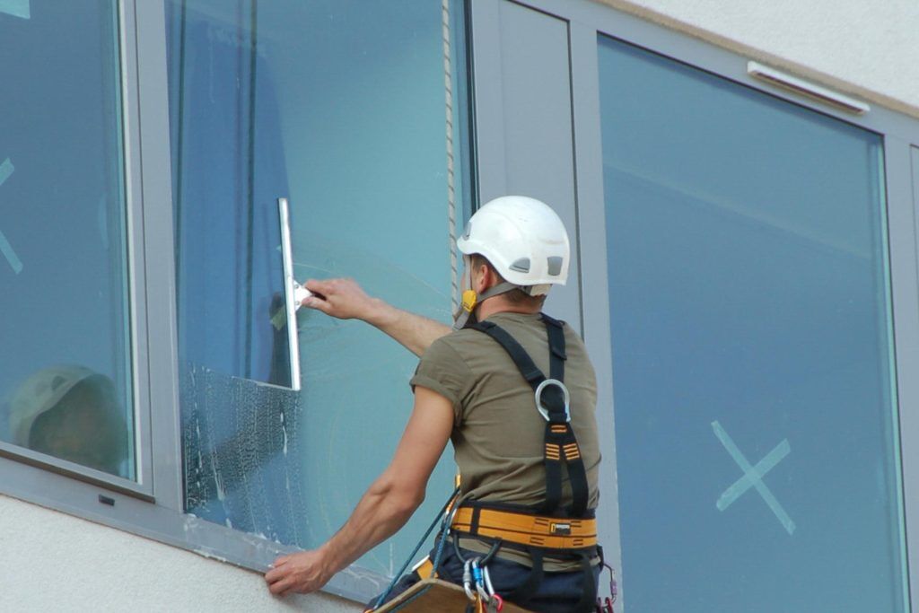 Man cleaning a window of a building