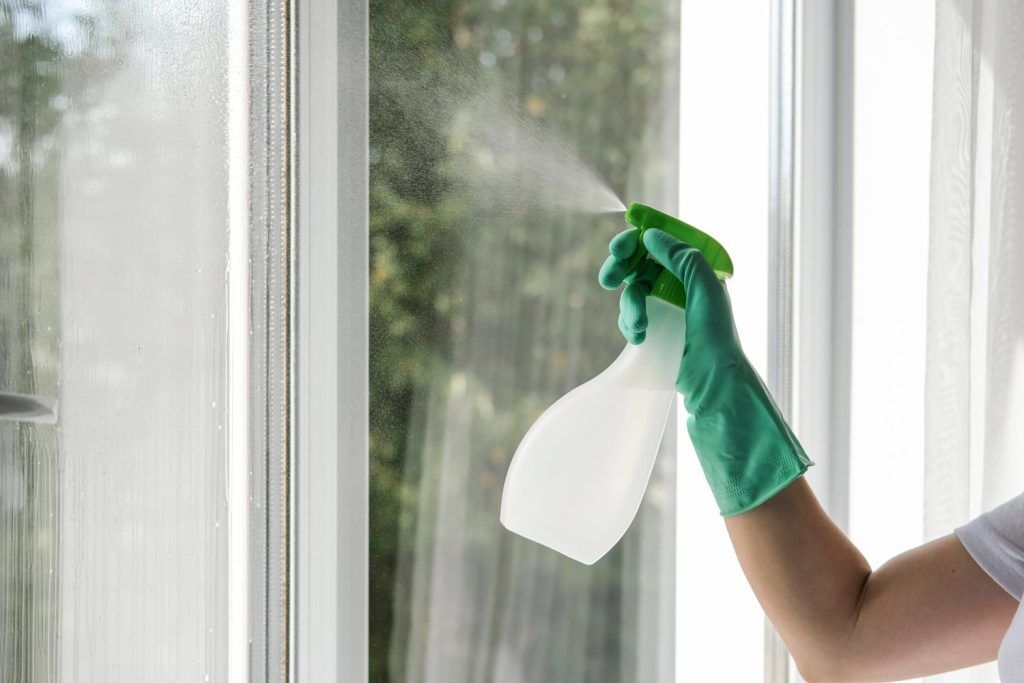 Spraying cleaning liquid on the window